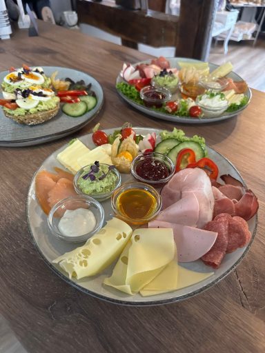 Bunte Käse- und Wurstplatte mit Gemüse, Dips und frischen Beilagen.